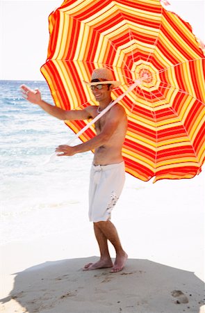 simsearch:644-01437256,k - Man marching on beach with beach umbrella Foto de stock - Royalty Free Premium, Número: 644-01437655