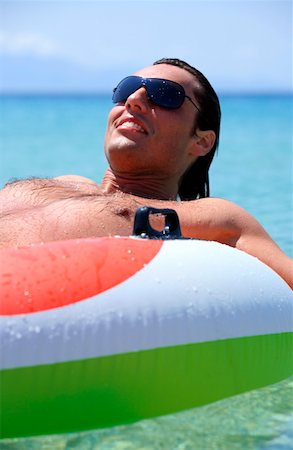skin and fit - Young man in water on inflatable life ring Stock Photo - Premium Royalty-Free, Code: 644-01437704