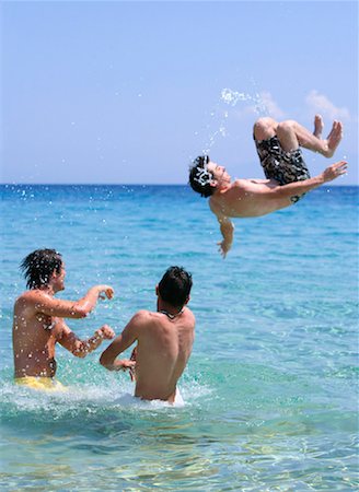Three young men playing in the water Stock Photo - Premium Royalty-Free, Code: 644-01437766