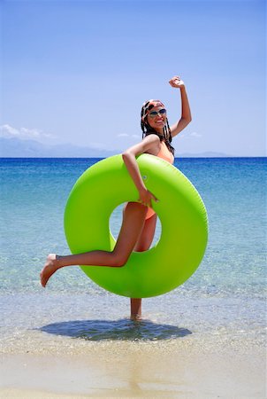 simsearch:644-01437538,k - Jeune femme sur la plage avec une bouée de sauvetage gonflable Photographie de stock - Premium Libres de Droits, Code: 644-01437780