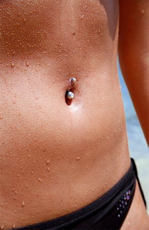 simsearch:862-03711658,k - Belly of young woman on beach with belly button ring Stock Photo - Premium Royalty-Free, Code: 644-01437901