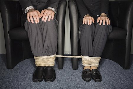 Male and female business people's legs tied Stock Photo - Premium Royalty-Free, Code: 644-01630906