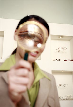 Woman with magnifying glass on eye Stock Photo - Premium Royalty-Free, Code: 644-01631056