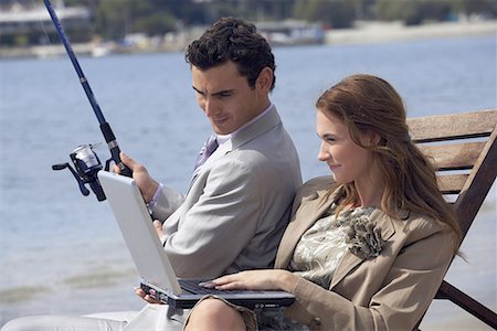 Business couple on beach with fishing rod and laptop Stock Photo - Premium Royalty-Free, Code: 644-01631169