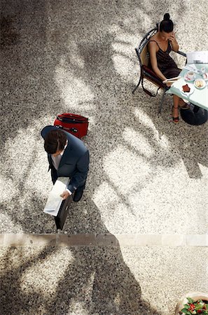 people waiting to meeting - Businesswoman at cafe table, businessman walking by with suitcase Stock Photo - Premium Royalty-Free, Code: 644-01631463