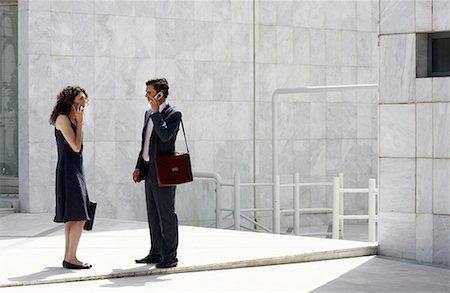 spanish male dress - Businessman and businesswoman on cell phones meeting Foto de stock - Sin royalties Premium, Código: 644-01631470