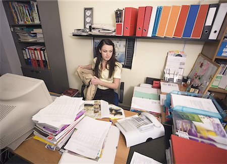 Female office worker at cluttered desk Stock Photo - Premium Royalty-Free, Code: 644-01825252