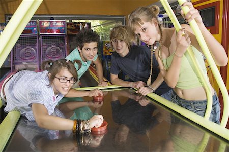 Teenagers playing game in arcade Stock Photo - Premium Royalty-Free, Code: 644-01825477