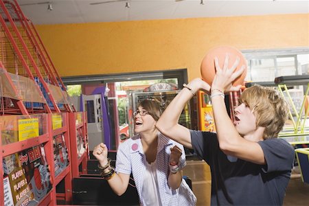 Teenagers playing game in arcade Stock Photo - Premium Royalty-Free, Code: 644-01825470