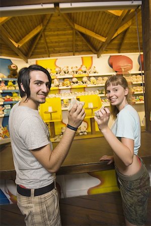 Teenage couple at game in amusement park Stock Photo - Premium Royalty-Free, Code: 644-01825647