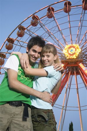 sunset hang out - Teenage couple at Ferris wheel in amusement park Foto de stock - Sin royalties Premium, Código: 644-01825642