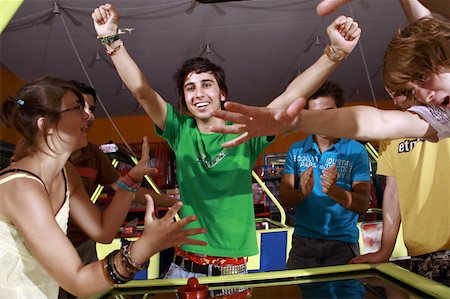 Teenagers playing game in arcade Stock Photo - Premium Royalty-Free, Code: 644-01825661