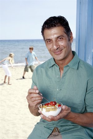 Male mature adult eating breakfast at beach Stock Photo - Premium Royalty-Free, Code: 644-02060568