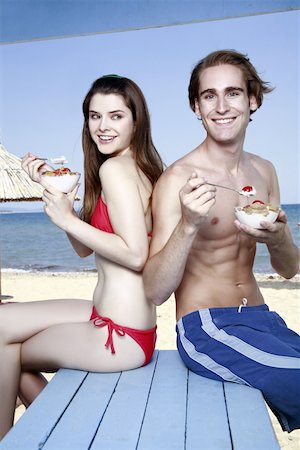 Young adult couple eating breakfast on beach Stock Photo - Premium Royalty-Free, Code: 644-02060581