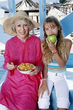 picture elderly people eating - Grandmother and granddaughter eating at beach Stock Photo - Premium Royalty-Free, Code: 644-02060617