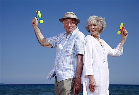 pistolet à eau - Senior couple sur la plage avec des pistolets à eau Photographie de stock - Premium Libres de Droits, Code: 644-02060677