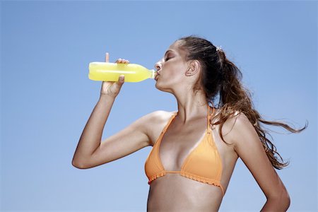 Female young adult drinking juice in bikini Stock Photo - Premium Royalty-Free, Code: 644-02060767