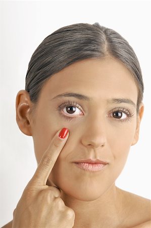 eye pointing - Female young adult;pointing to eye Stock Photo - Premium Royalty-Free, Code: 644-02152705