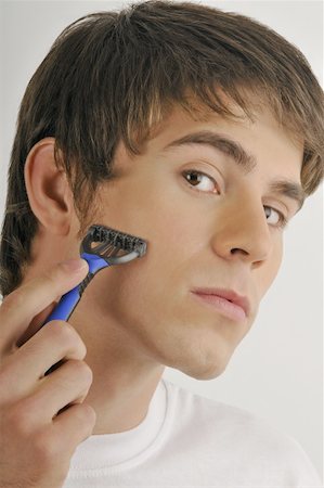 simsearch:644-02152773,k - Young male adult shaving face with razor Stock Photo - Premium Royalty-Free, Code: 644-02152758