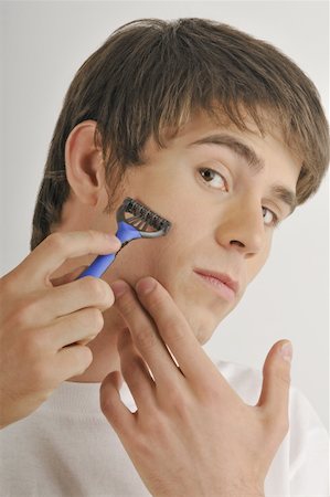 simsearch:644-02152773,k - Young male adult shaving face with razor Stock Photo - Premium Royalty-Free, Code: 644-02152764
