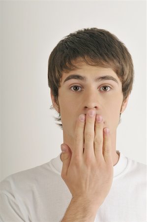 Young male adult;hand to mouth Stock Photo - Premium Royalty-Free, Code: 644-02152767