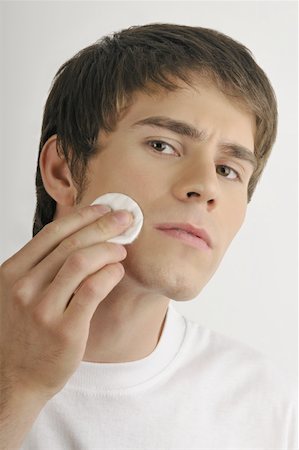 simsearch:644-02152773,k - Young male adult cleaning face with cotton pad Stock Photo - Premium Royalty-Free, Code: 644-02152773