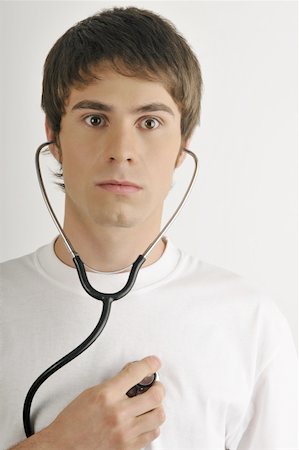 Young male adult;listening to his heart with stethoscope Stock Photo - Premium Royalty-Free, Code: 644-02152782