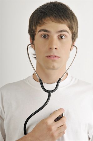 stethoscope heart - Young male adult;listening to his heart with stethoscope Stock Photo - Premium Royalty-Free, Code: 644-02152783