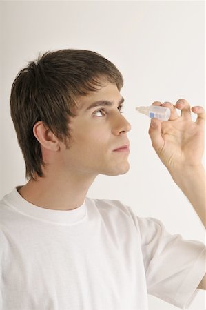 Jeune mâle adulte avec bouteille de gouttes oculaires Photographie de stock - Premium Libres de Droits, Code: 644-02152796