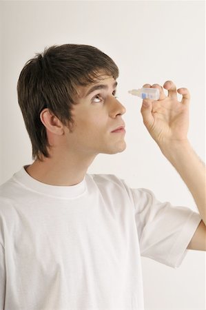 Jeune mâle adulte avec bouteille de gouttes oculaires Photographie de stock - Premium Libres de Droits, Code: 644-02152797