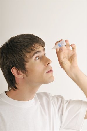 Jeune mâle adulte avec bouteille de gouttes oculaires Photographie de stock - Premium Libres de Droits, Code: 644-02152798