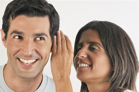 Female young adult whispering in man's ear Stock Photo - Premium Royalty-Free, Code: 644-02152885