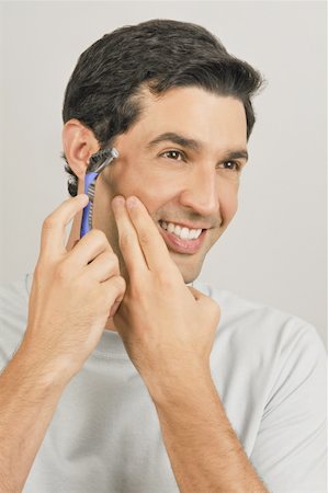 Young male adult shaving face with razor Stock Photo - Premium Royalty-Free, Code: 644-02152976