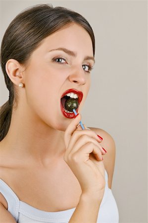 simsearch:644-02153100,k - Female young adult biting a lollipop Stock Photo - Premium Royalty-Free, Code: 644-02153081