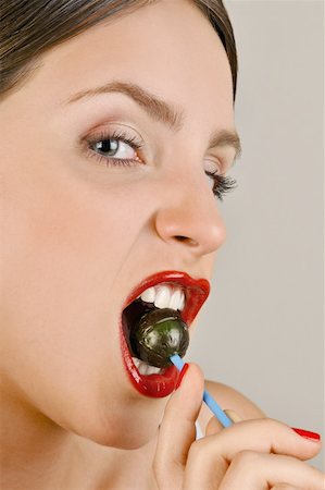 simsearch:644-02153082,k - Female young adult biting a lollipop Foto de stock - Sin royalties Premium, Código: 644-02153083