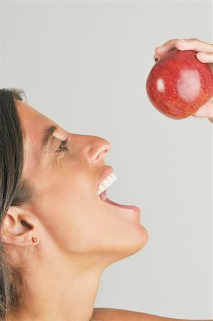 portrait of woman with fruit on head - Femelle adulte mange une pomme Photographie de stock - Premium Libres de Droits, Code: 644-02153100