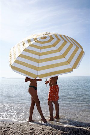 Couple on the beach under umbrella Stock Photo - Premium Royalty-Free, Code: 644-02153136