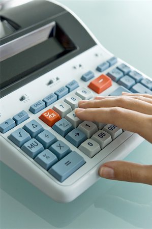 Closeup of woman's hand using calculator Stock Photo - Premium Royalty-Free, Code: 644-02922947