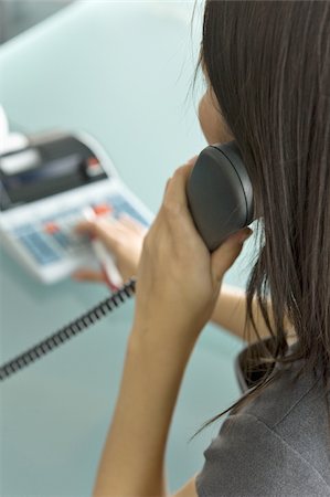 Professional woman on telephone using calculator Foto de stock - Sin royalties Premium, Código: 644-02922941