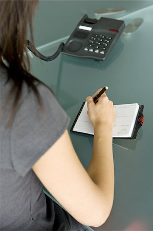 secretary and her telephone - Professional woman on telephone writing in agenda Stock Photo - Premium Royalty-Free, Code: 644-02922958