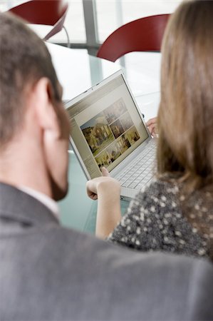 spanish mediterranean houses interiors - Woman showing man web site on laptop computer Stock Photo - Premium Royalty-Free, Code: 644-02922972