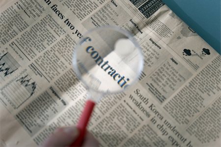 Magnifying glass over financial section of newspaper Fotografie stock - Premium Royalty-Free, Codice: 644-02923008