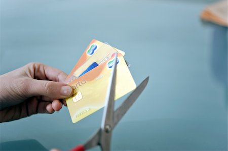 Mains coupant les cartes de crédit avec des ciseaux Photographie de stock - Premium Libres de Droits, Code: 644-02923009