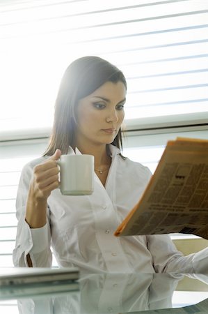 Professional woman reading newspaper and drinking coffee Stock Photo - Premium Royalty-Free, Code: 644-02923034