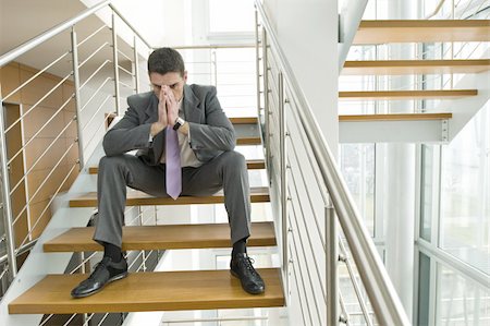 Businessman on office staircase with face in hands Stock Photo - Premium Royalty-Free, Code: 644-02923131