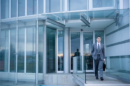 people walking into office building - Businessman exiting from office building Stock Photo - Premium Royalty-Free, Code: 644-02923147
