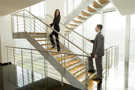 simsearch:644-02923130,k - Businesswoman and businessman walking up office staircase Foto de stock - Royalty Free Premium, Número: 644-02923206