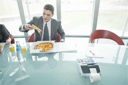 people eating at work - Business people eating pizza at desk Stock Photo - Premium Royalty-Free, Code: 644-02923235