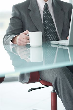 Businessman at laptop computer with coffee cup Stock Photo - Premium Royalty-Free, Code: 644-02923257