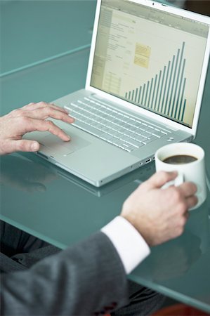 simsearch:644-02923242,k - Businessman's hands with coffee cup at laptop with bar chart Stock Photo - Premium Royalty-Free, Code: 644-02923260